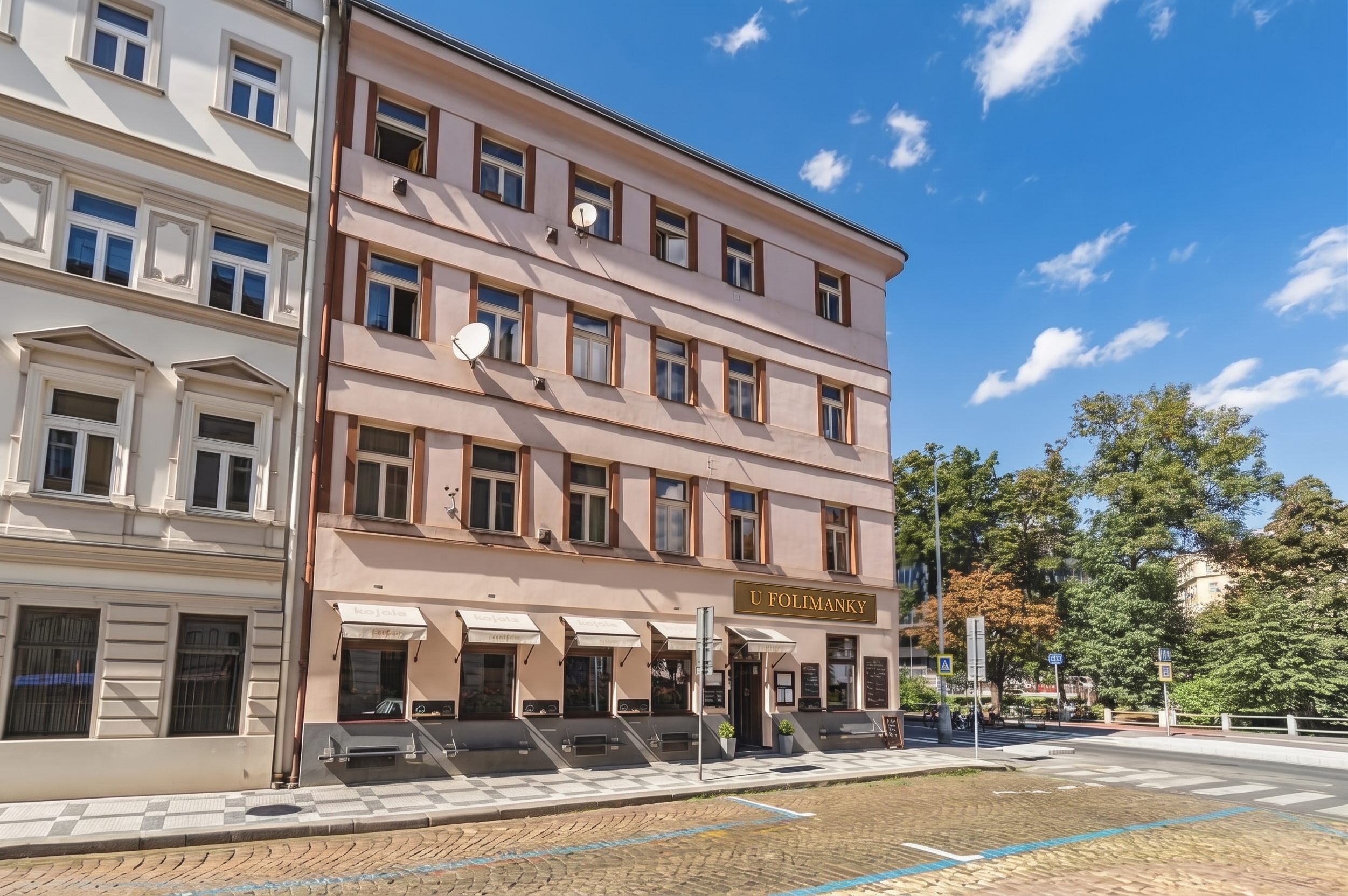 Budova a exteriér restaurace U Folimanky s vývěsním štítem a markýzami